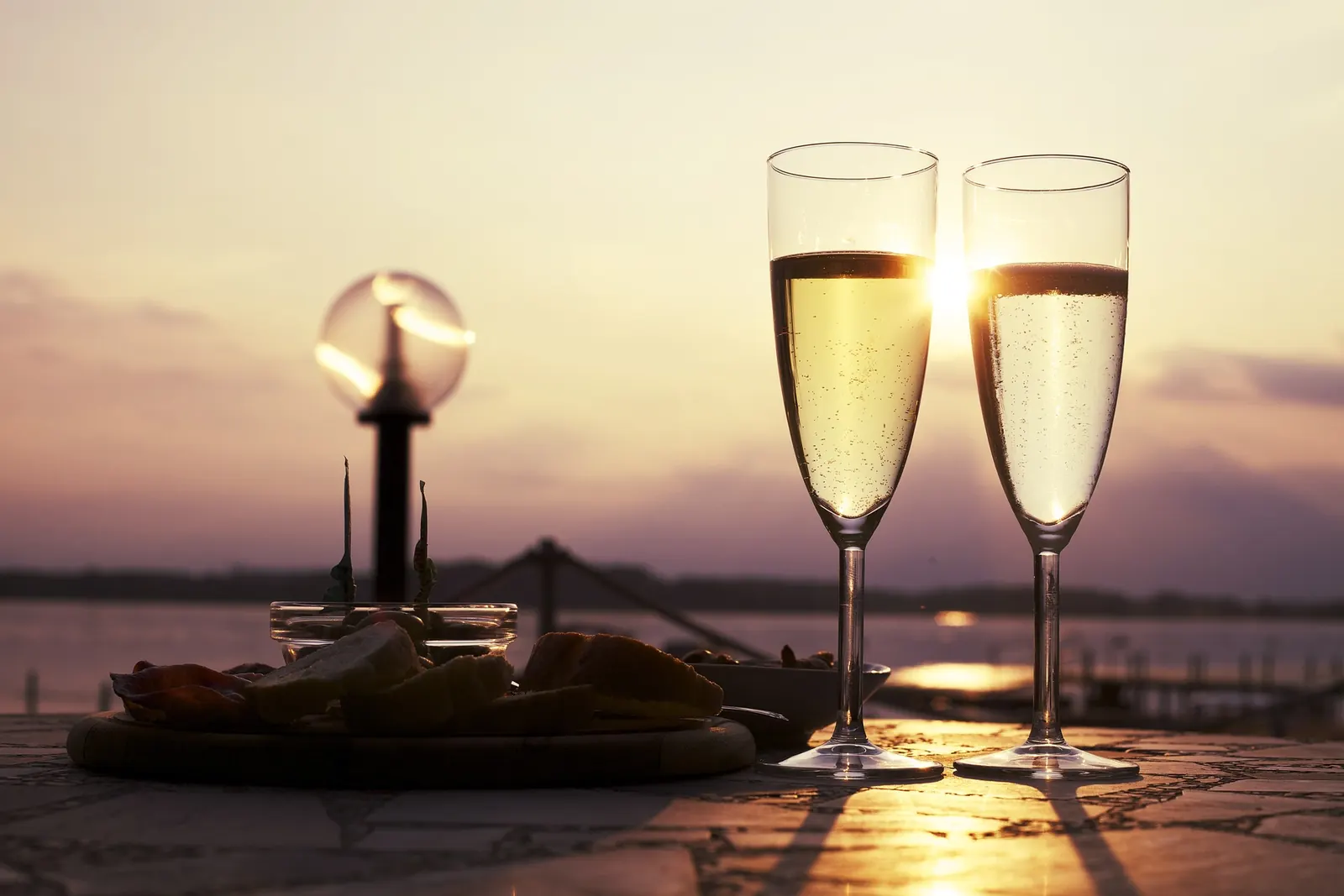 Two glasses of champagne at sunset by the water