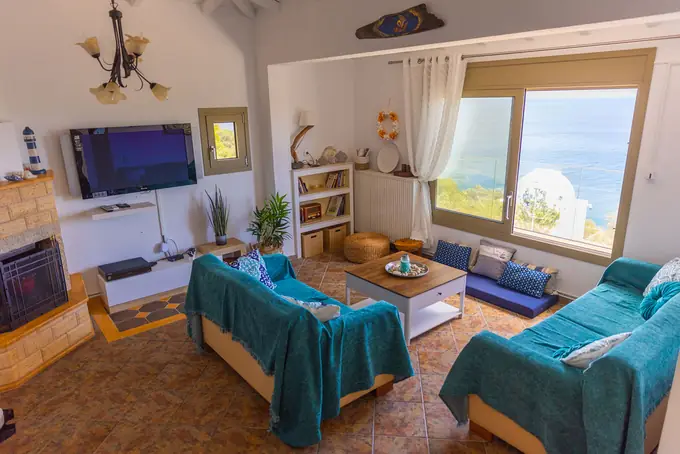 The living room with its stone fireplace and sea-view window