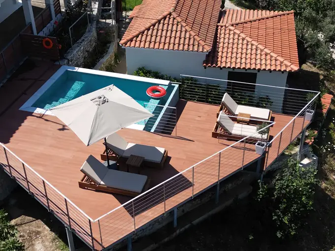 Sunbeds and an umbrella on the deck beside the pool