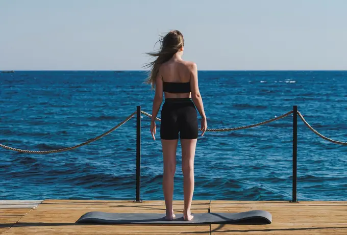 Standing on a mat on a jetty by the sea
