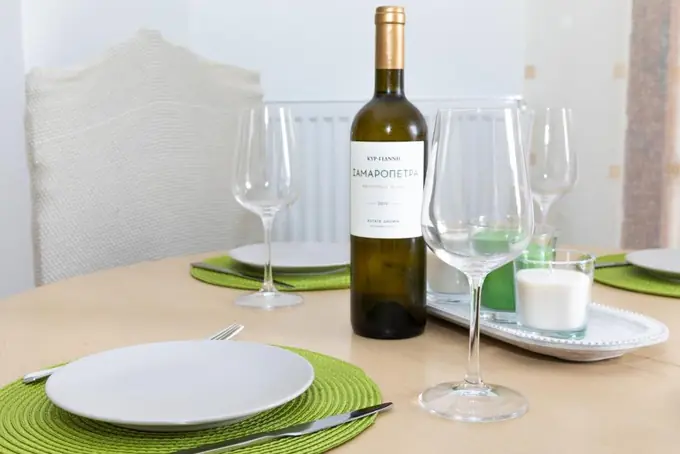 A table laid with glasses and a bottle of white wine