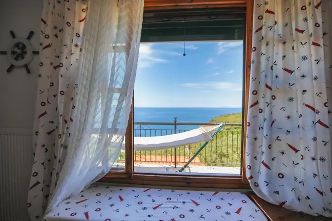 Curtains open onto the hammock and the sea
