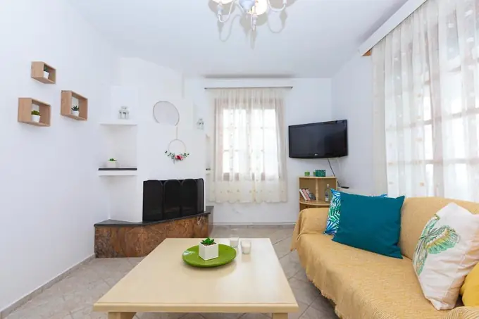 Living room with a fireplace, TV and yellow sofa