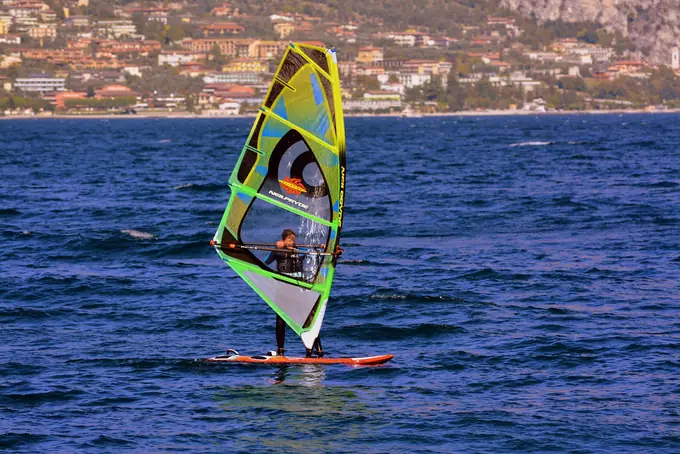 A windsurfer in front of a coastal town